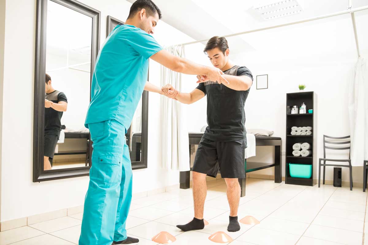 Physical therapist helping a man work on his balance