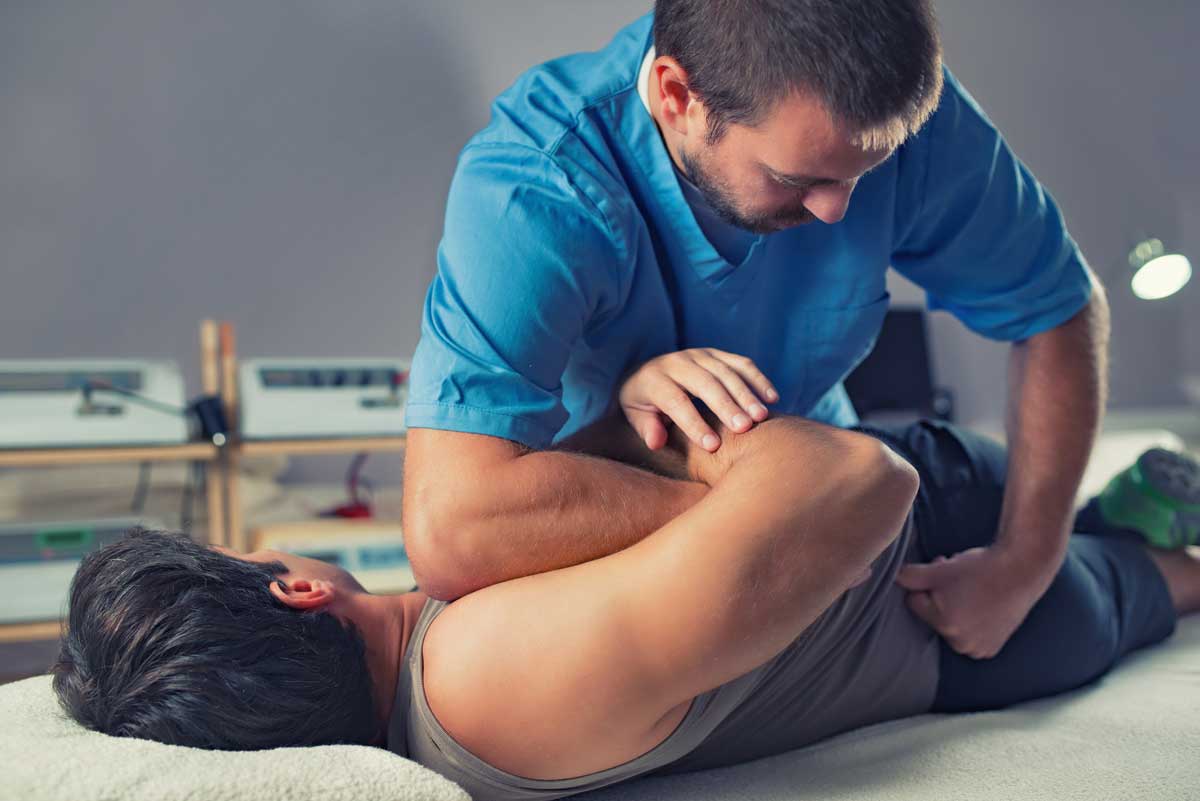 Physical therapist providing chiropractic services to a man