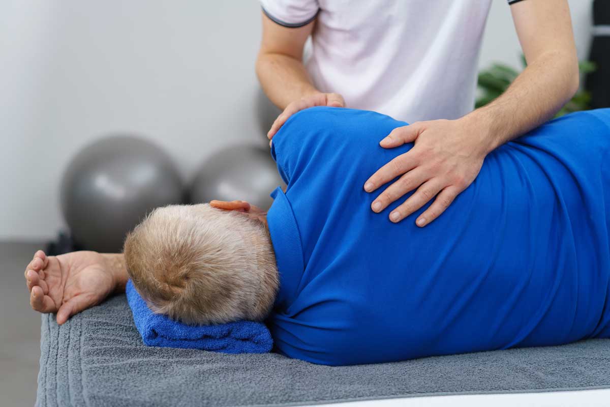 Physical therapist working on a neck & back for a older man