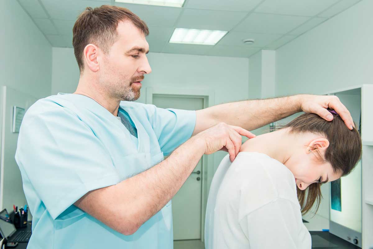 Physical therapist looking at the spine of a woman